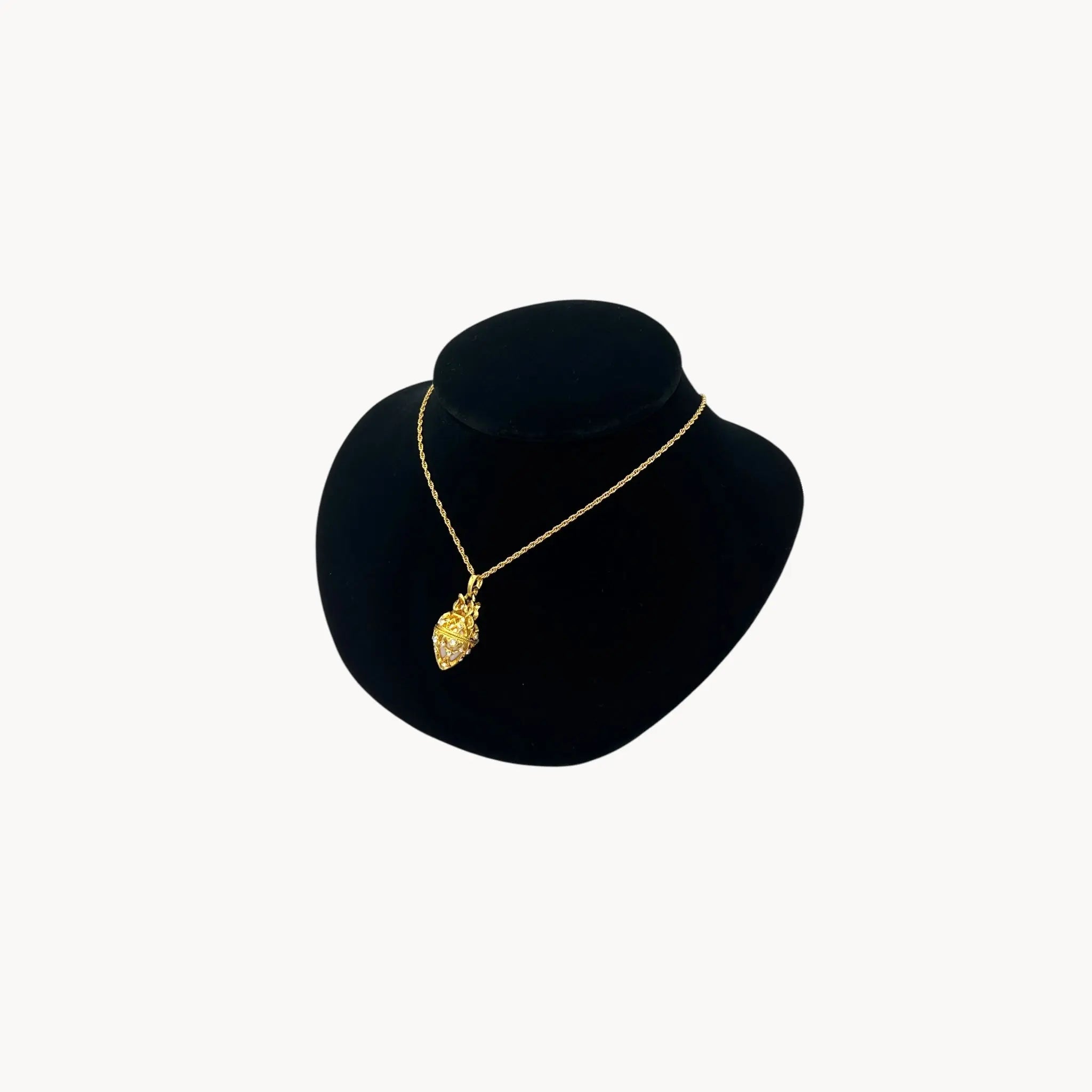 Side view of Joan Rivers gold egg locket necklace on long chain