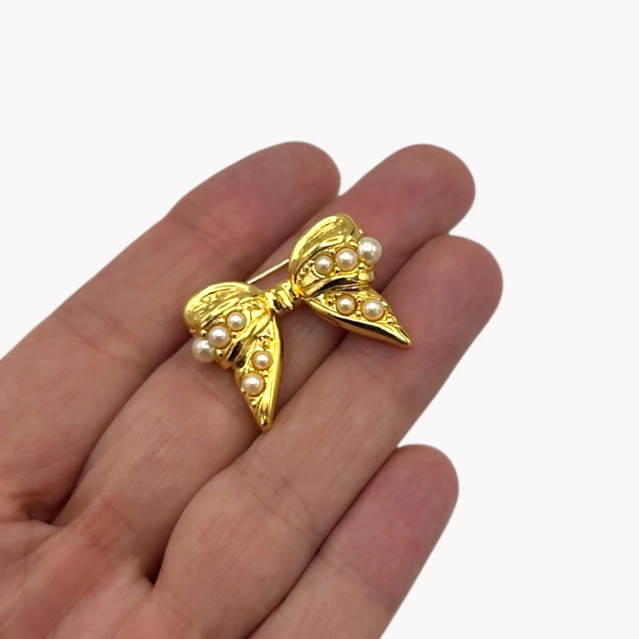 Size scale picture of Joan Rivers gold-tone bow brooch with petite faux pearls, vintage jewelry.