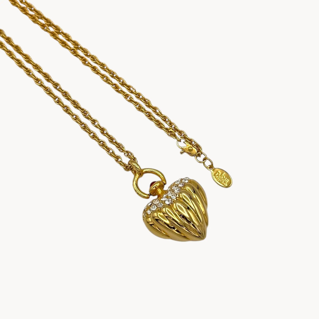 Close up view on white background of Joan Rivers gold heart pendant necklace with crystal accents on chain, vintage 1990s statement jewelry.