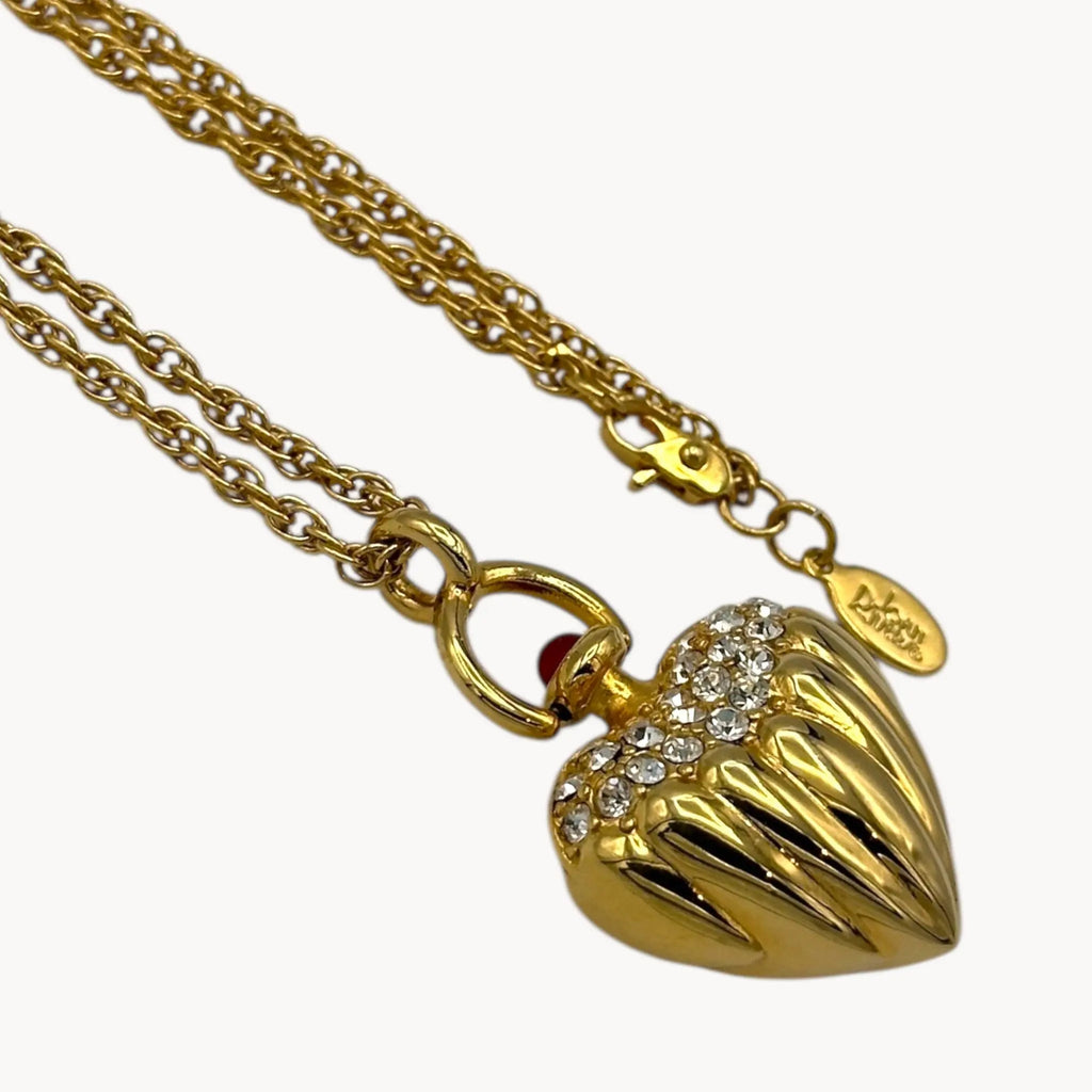 Very close up view of Joan Rivers gold heart pendant necklace with crystal accents on chain, vintage 1990s statement jewelry.