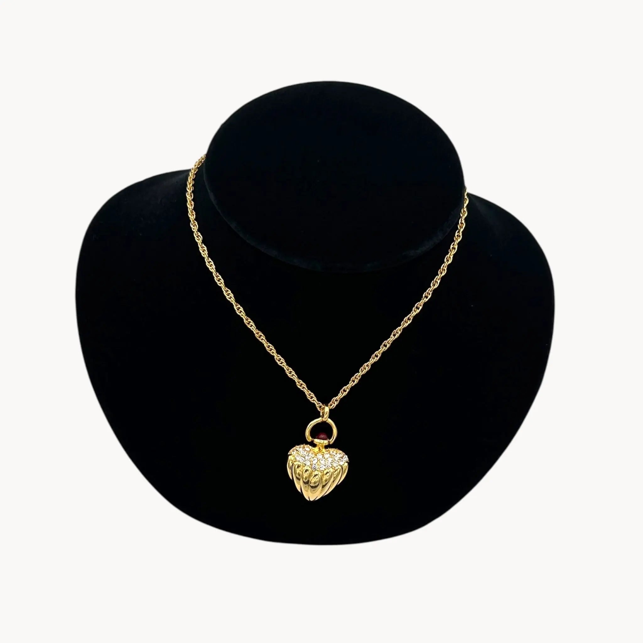 Close up view of Joan Rivers gold heart pendant necklace with crystal accents on chain, vintage 1990s statement jewelry.