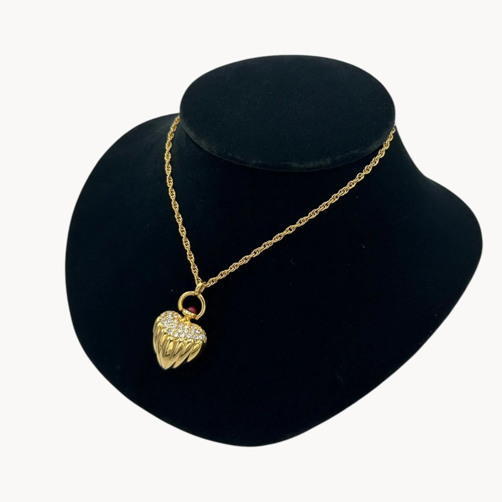 Close up side view of Joan Rivers gold heart pendant necklace with crystal accents on chain, vintage 1990s statement jewelry.