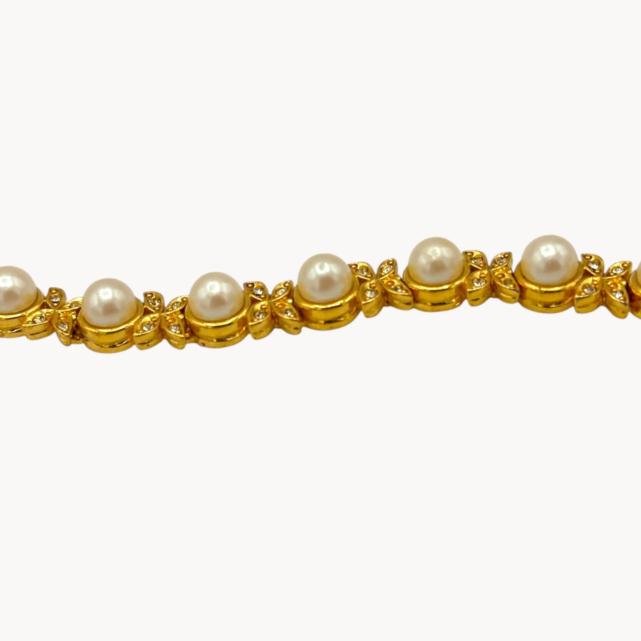 Close up of view of Joan Rivers gold bracelet with pearls and rhinestones.