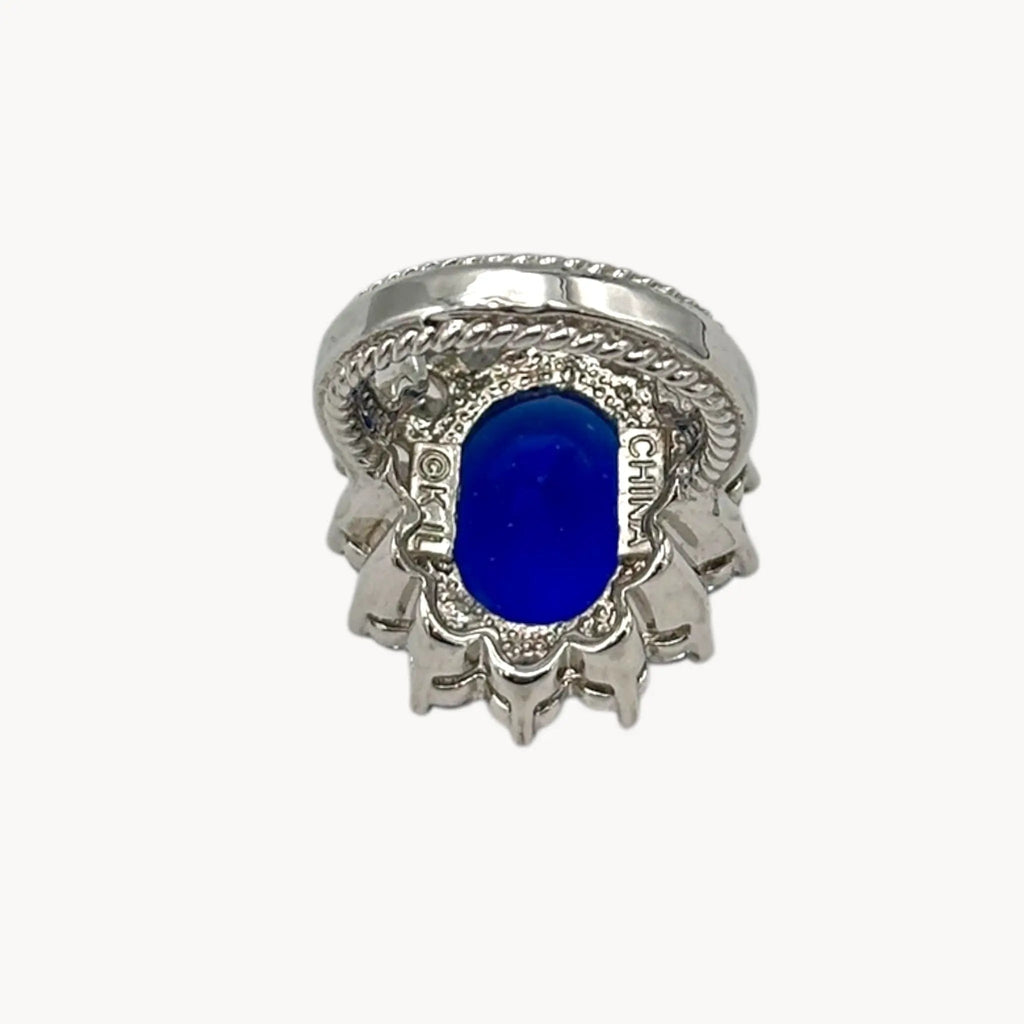 Inside view of Kenneth Jay Lane blue oval crystal cocktail ring inspired by Princess Diana’s sapphire engagement ring on white background.