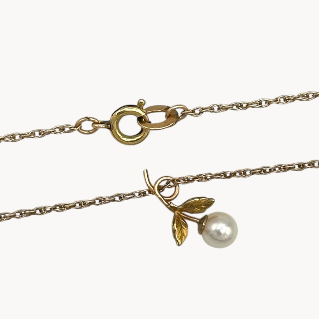 Close up of pearl flower on Krementz dainty gold flower pendant necklace with pearl center.