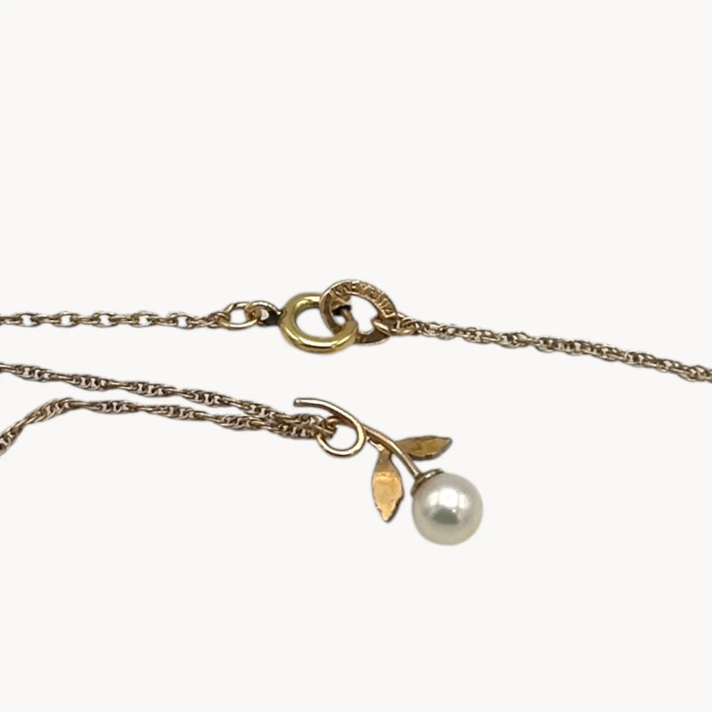 Back view of Krementz dainty gold flower pendant necklace with pearl center.