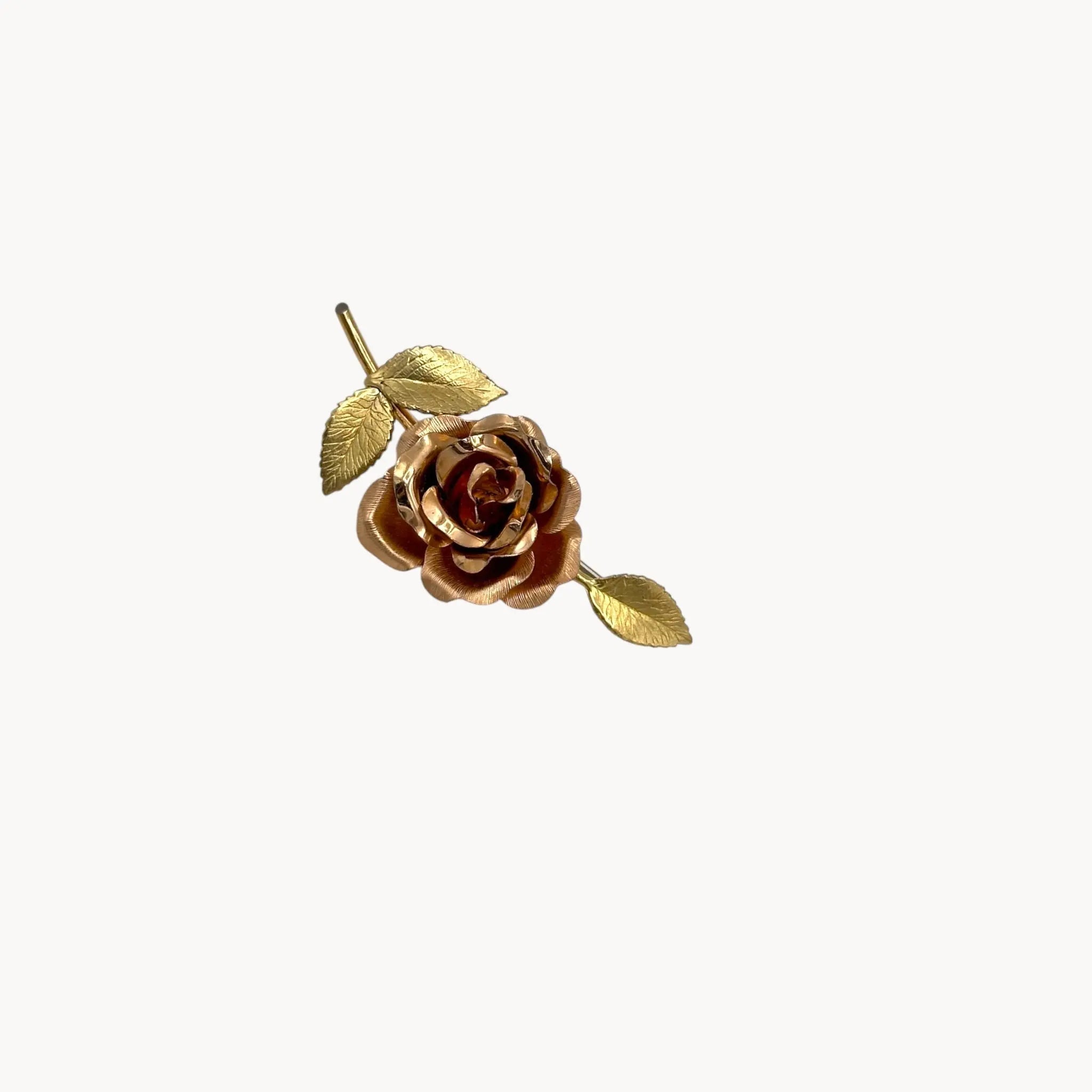 Close up view of Vintage Krementz gold rose flower brooch with textured leaves.