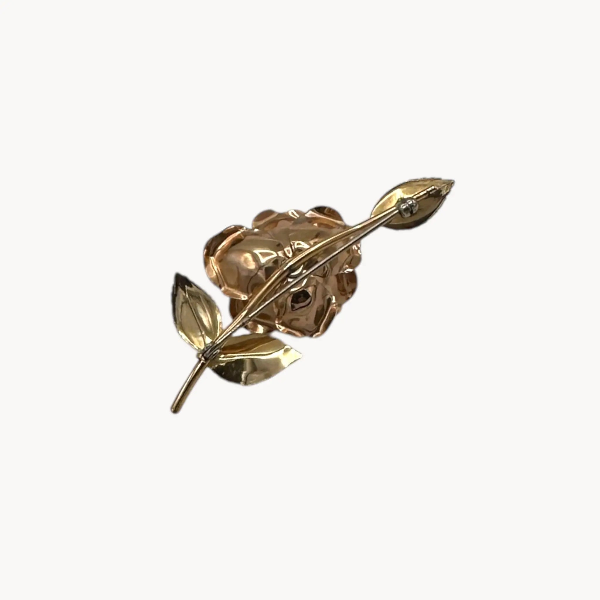 Back view of Vintage Krementz gold rose flower brooch with textured leaves.