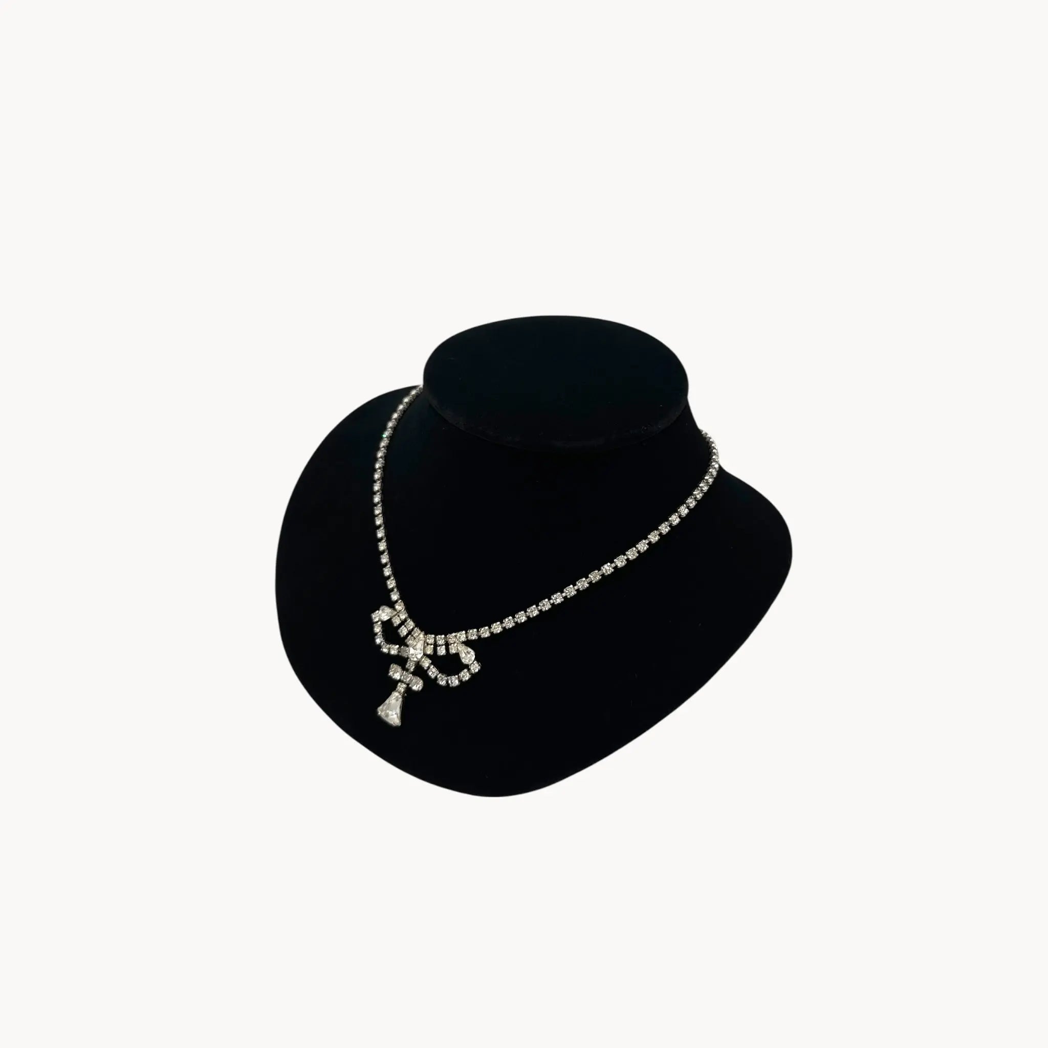 Side view 1950s Leo Glass rhinestone necklace with bow centerpiece and teardrop pendant, vintage mid-century bridal jewelry.