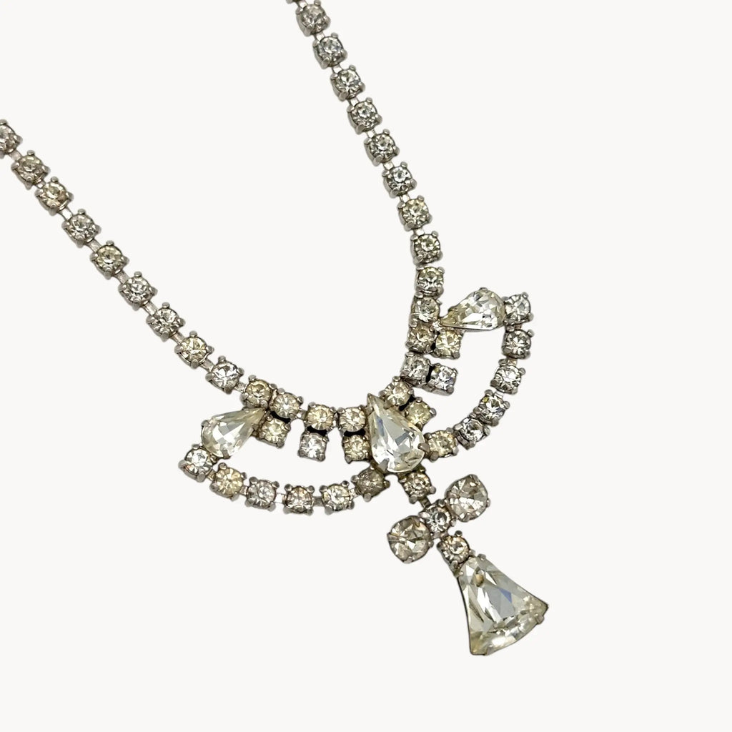 Close up of pendant view 1950s Leo Glass rhinestone necklace with bow centerpiece and teardrop pendant, vintage mid-century bridal jewelry.