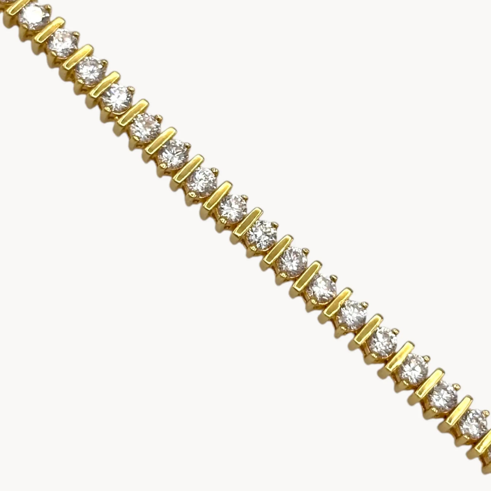 Close up view of Lind 14K gold electroplated clear CZ tennis bracelet on white background.