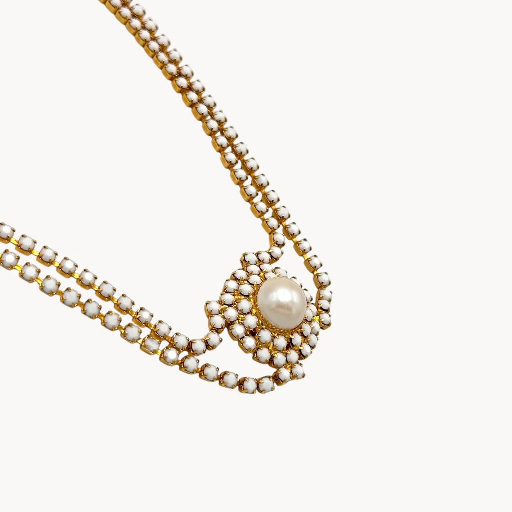 Close up view of Mid-century milk glass rhinestone bridal choker necklace with central pearl medallion.