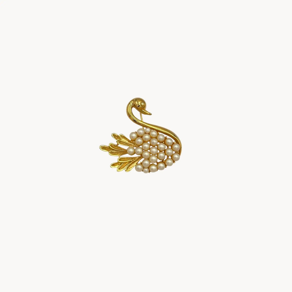 Close up of Midcentury gold swan brooch with faux pearls