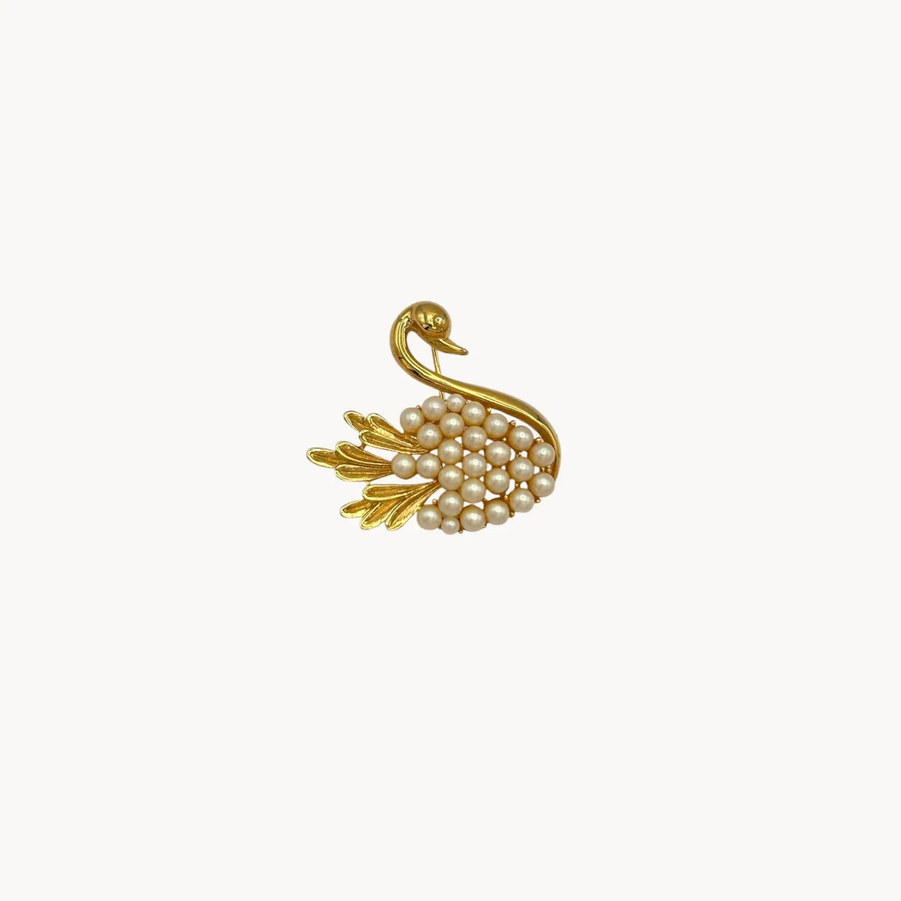 Close up of Midcentury gold swan brooch with faux pearls