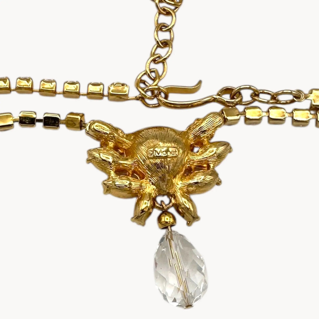 Back view of pendant of Vintage Monet gold necklace and clip-on earring set with clear heart and pink rhinestones.