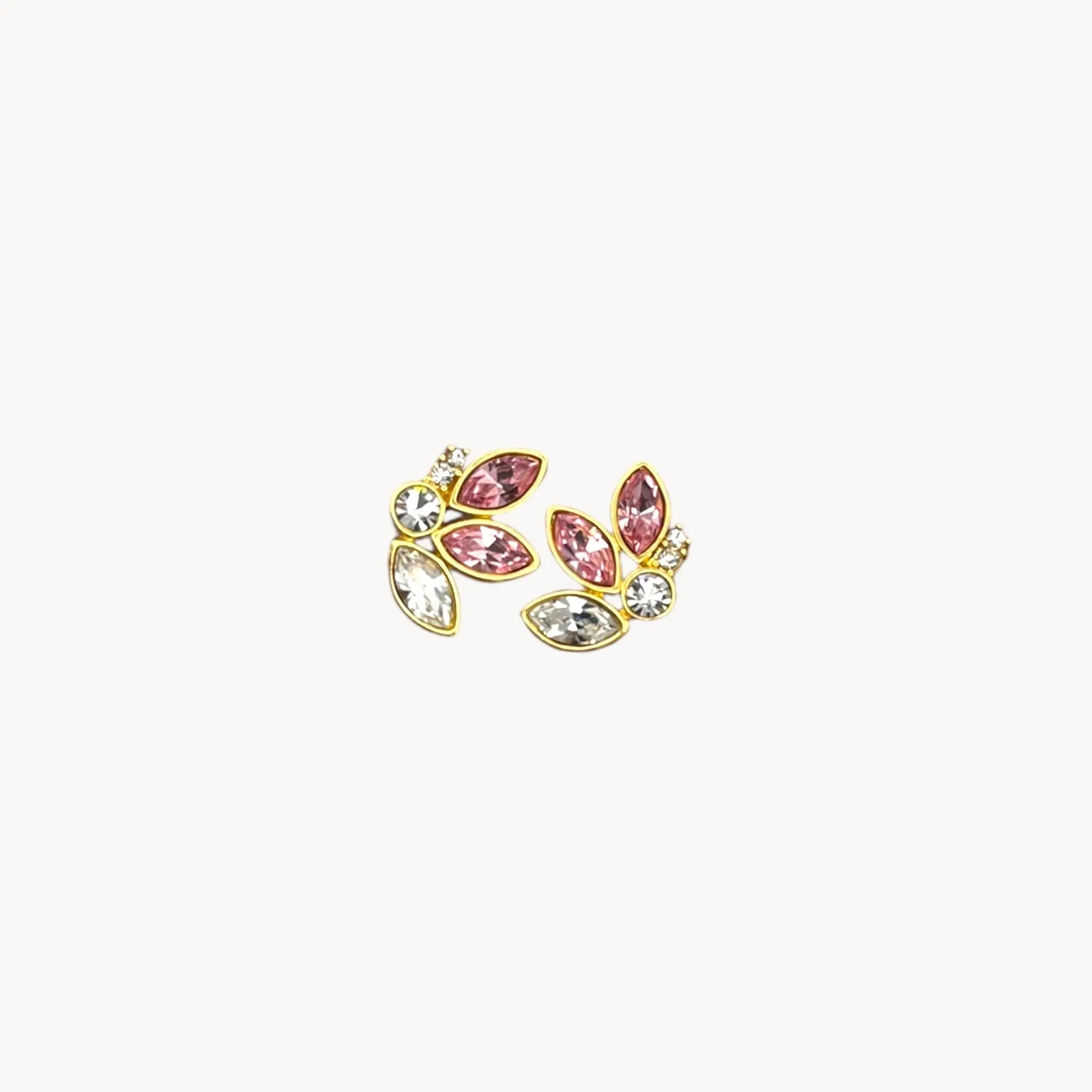 Close up view of Monet gold-tone clip-on earrings with pink and clear marquise rhinestones on white background.