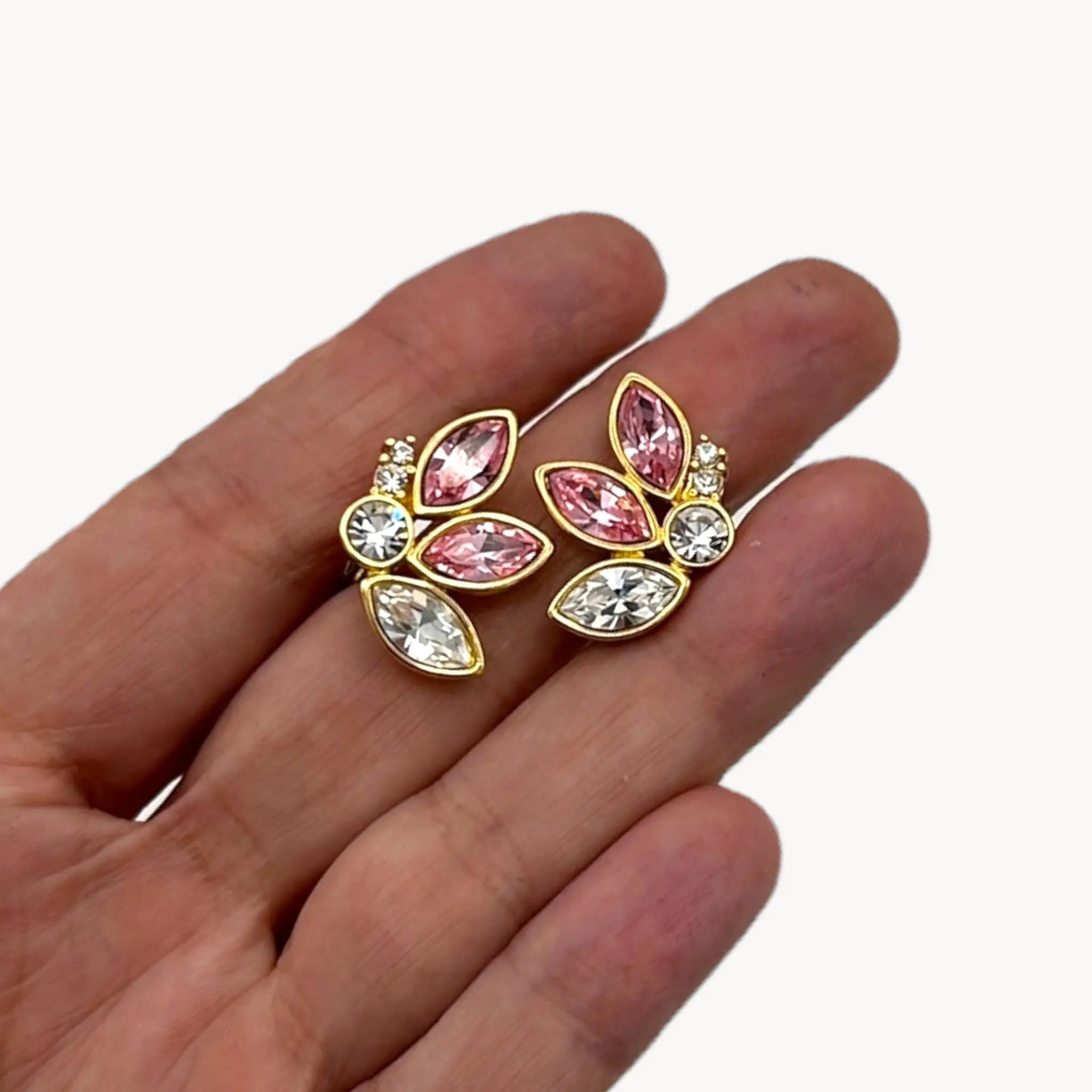 Scale close up view of Monet gold-tone clip-on earrings with pink and clear marquise rhinestones.