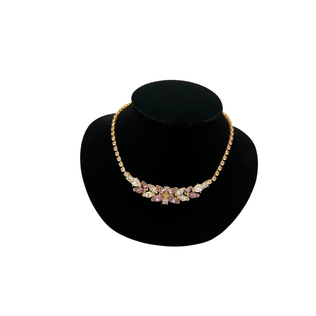 Close up view of Monet vintage pink and clear rhinestone floral necklace on gold-tone chain, romantic bridal jewelry.
