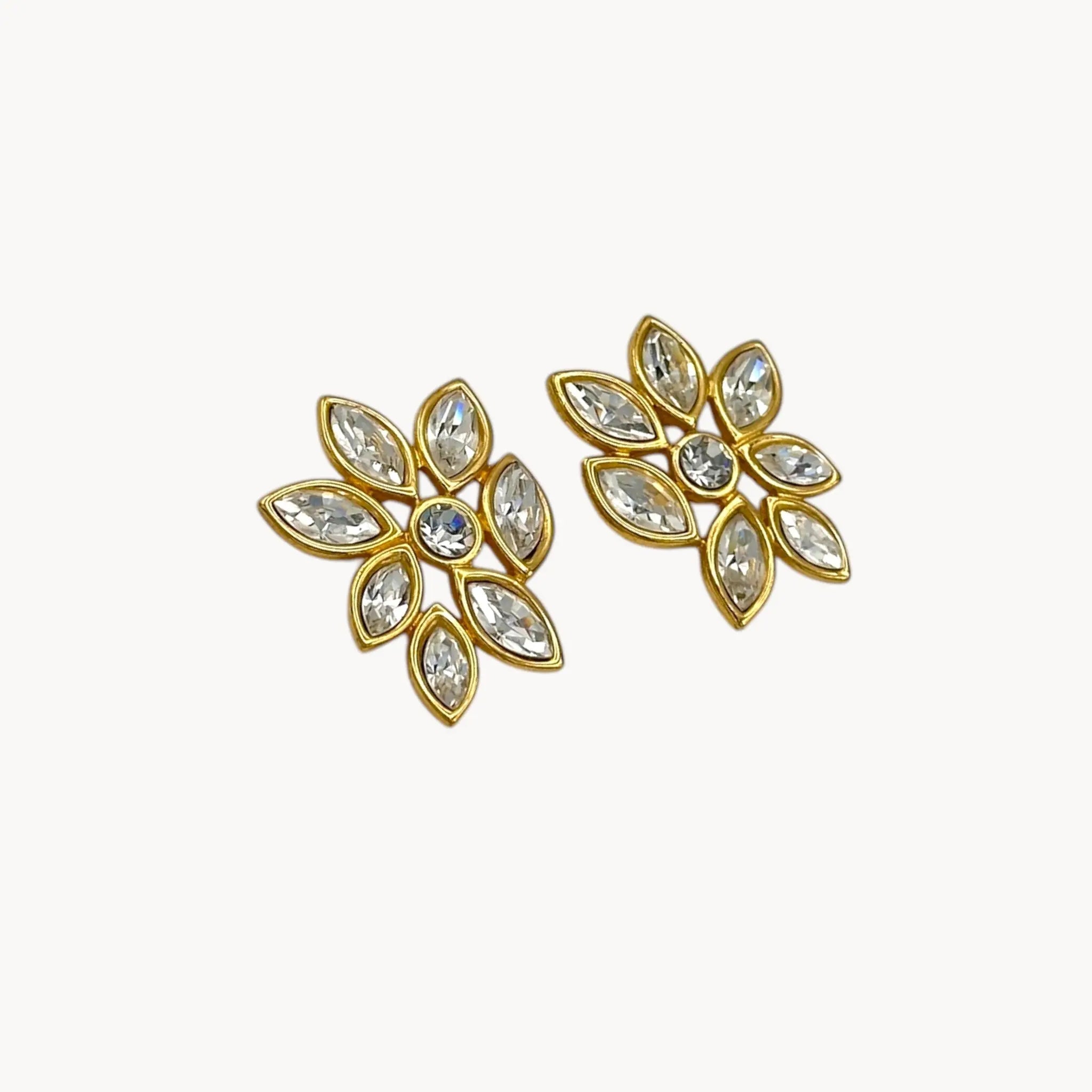 Side view of Monet vintage gold tone pierced earrings with clear marquise rhinestones arranged in a floral pattern, elegant 1980s bridal jewelry shown on white background.