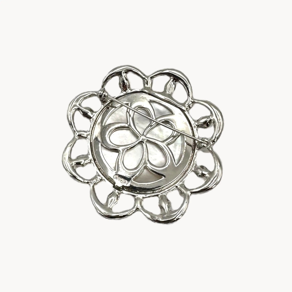 Back view of Monet vintage silver tone brooch with rhinestones and faux pearls in floral design, elegant bridal jewelry piece on white background.