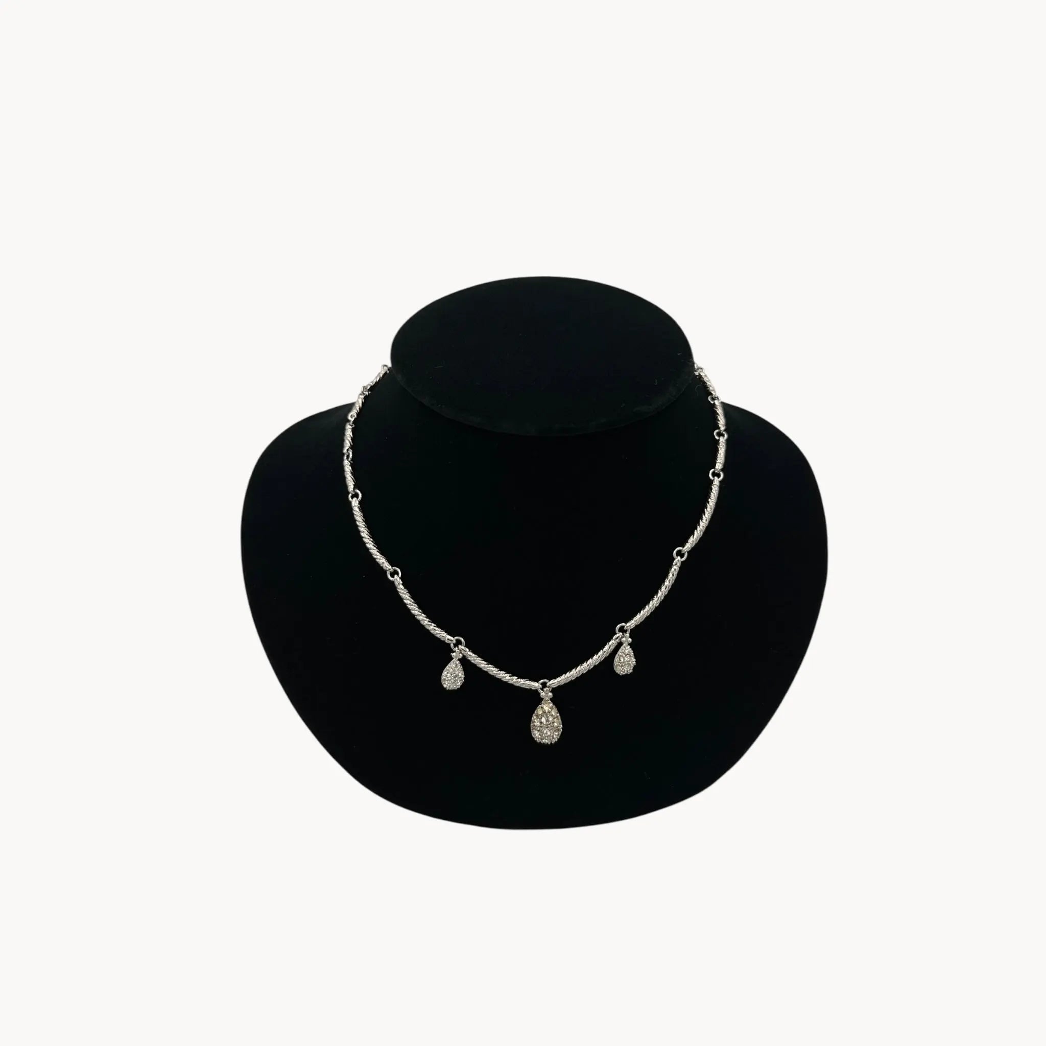 Close up view of Nolan Miller silver adjustable necklace with removable rhinestone teardrop dangles, vintage bridal jewelry.