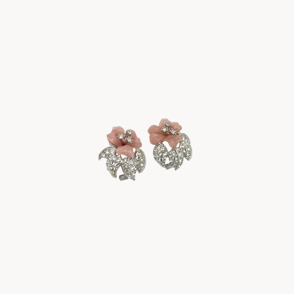 Side view of Nolan Miller vintage pink flower clip-on earrings with rhinestone accents and silver-tone leaves