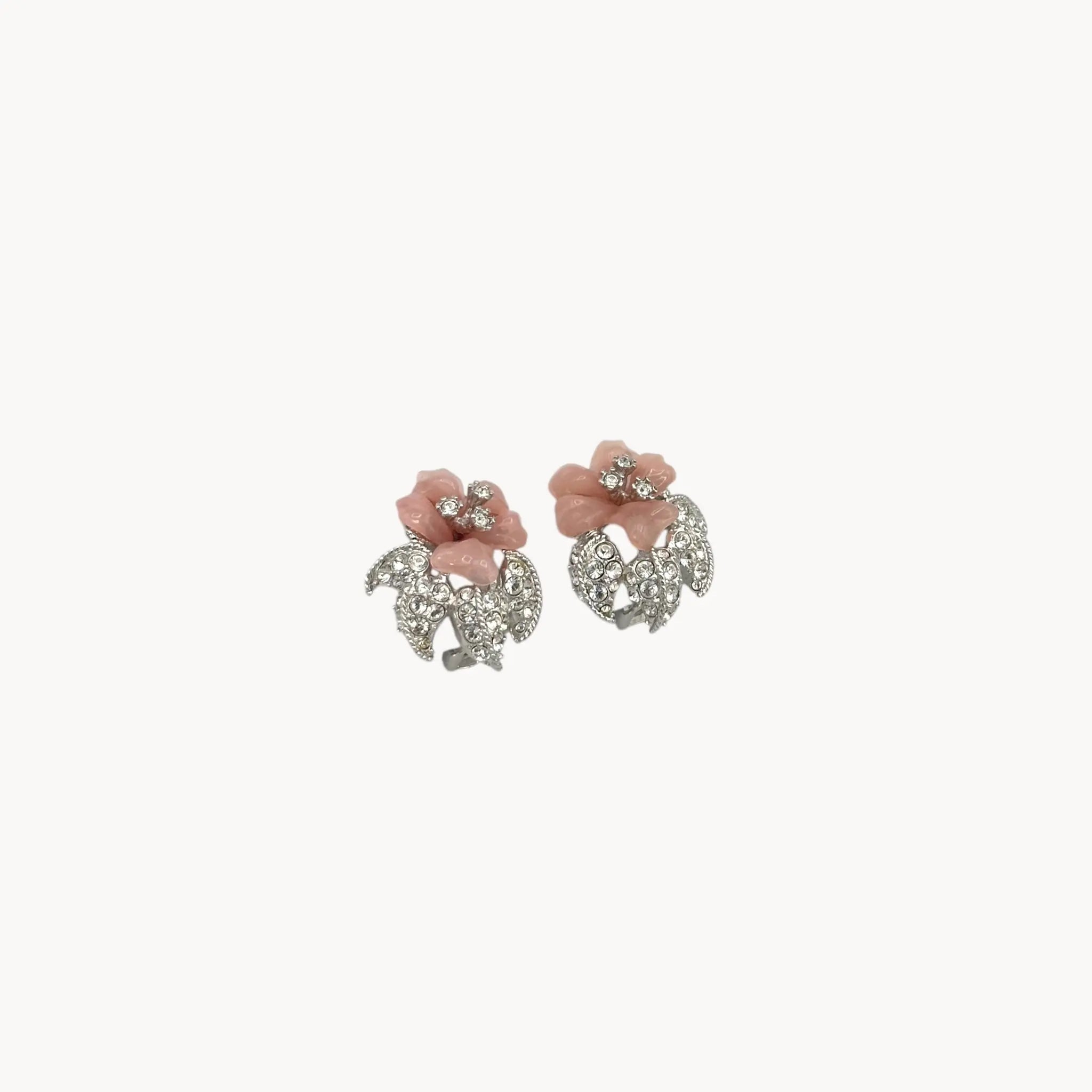 Side view of Nolan Miller vintage pink flower clip-on earrings with rhinestone accents and silver-tone leaves