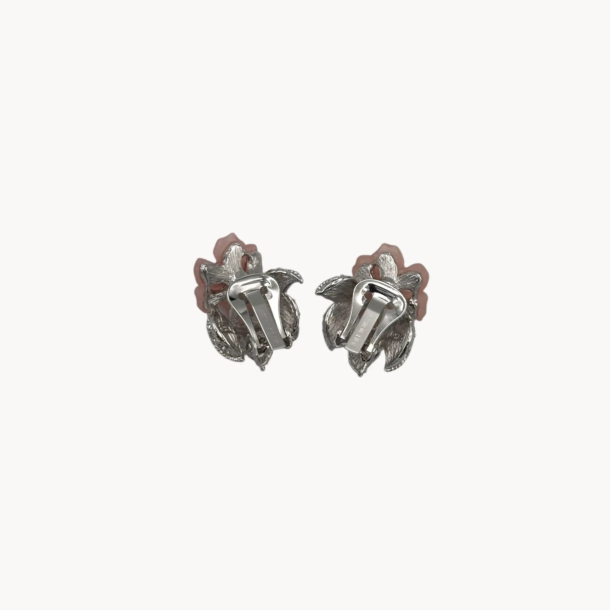 Back view of Nolan Miller vintage pink flower clip-on earrings with rhinestone accents and silver-tone leaves