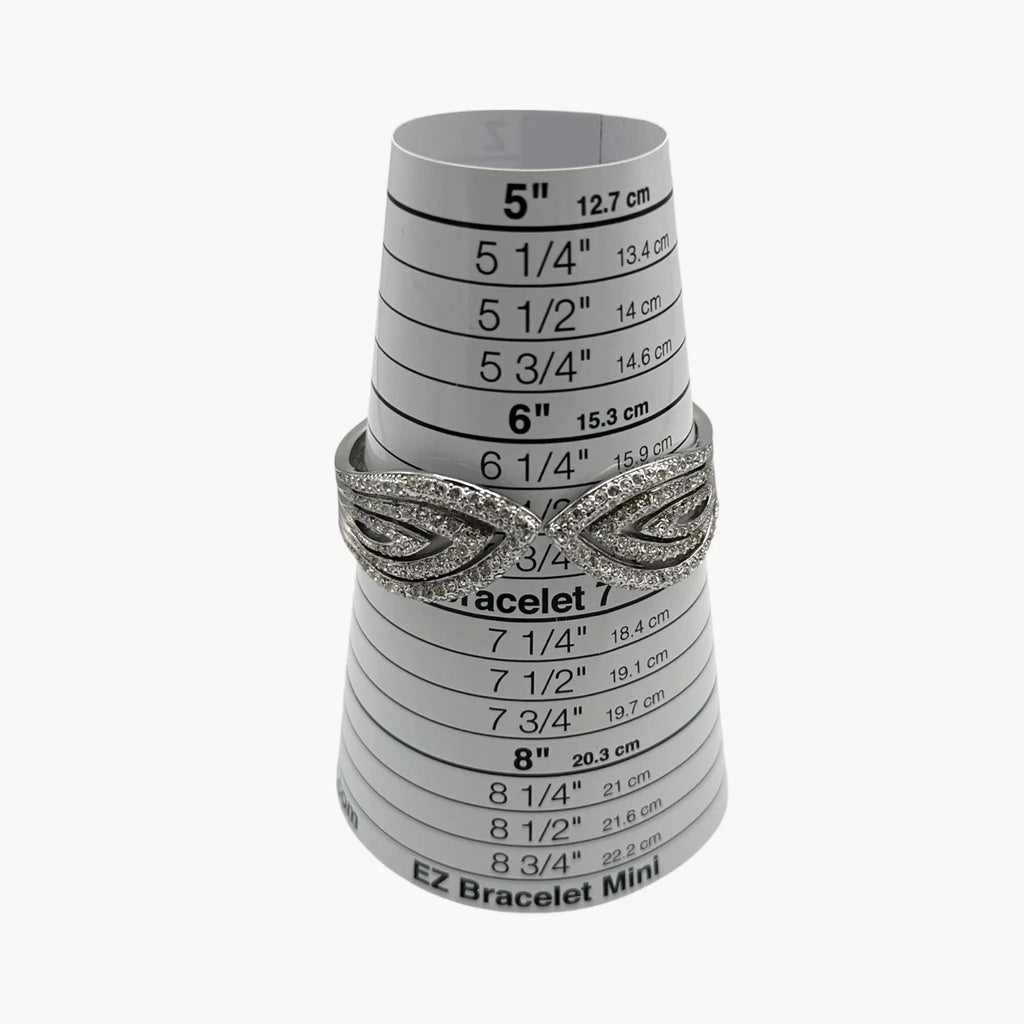 Size view of Nolan Miller silver rhinestone hinged bangle bracelet with overlapping design.