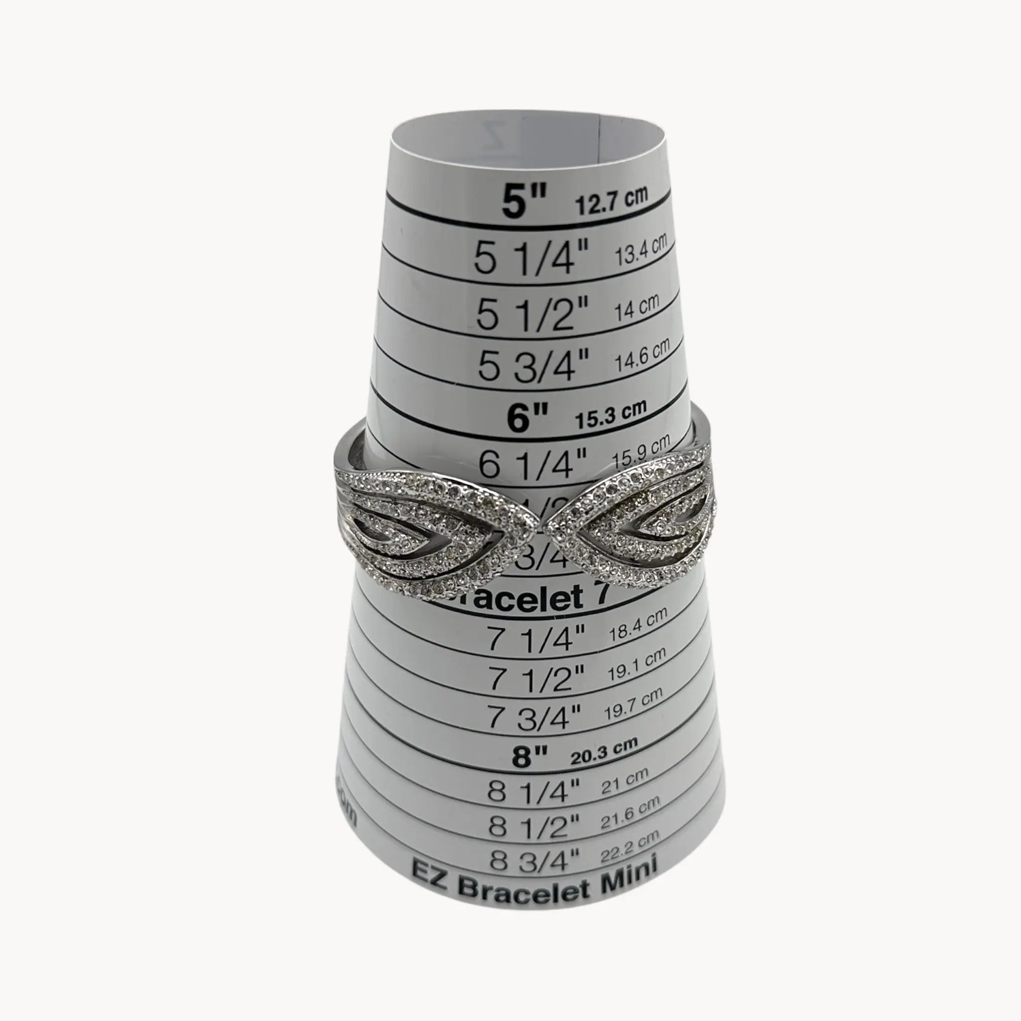 Size view of Nolan Miller silver rhinestone hinged bangle bracelet with overlapping design.