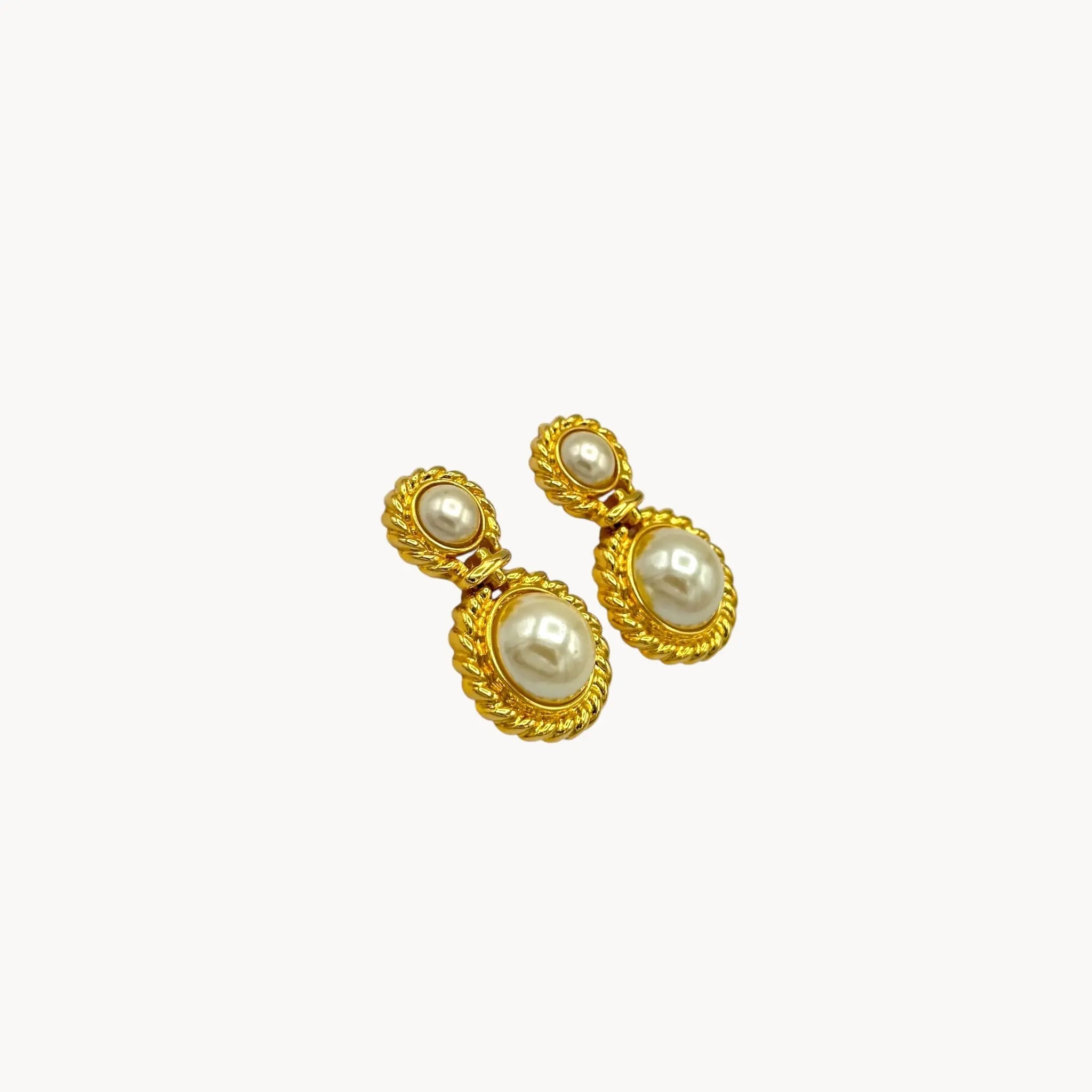 Side view of Vintage Paquette gold rope dangle earrings with faux pearls on white background.