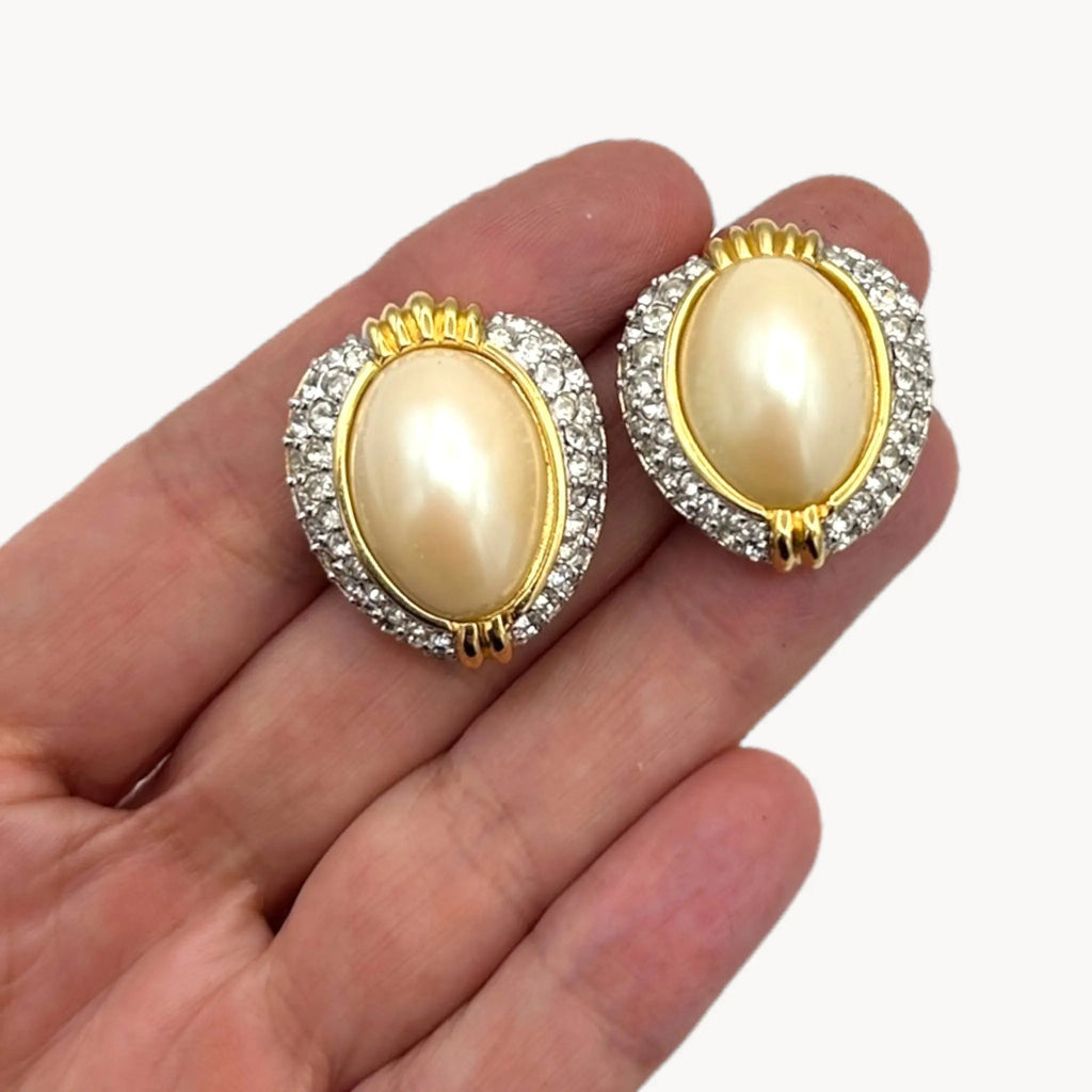 Scal view of Richelieu gold-tone faux pearl clip-on earrings with rhinestone accents, vintage jewelry on white background.
