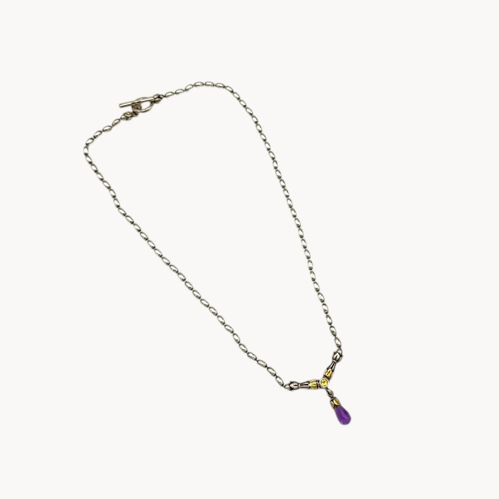 Sterling silver and 14K yellow gold necklace with amethyst teardrop pendant on white background.