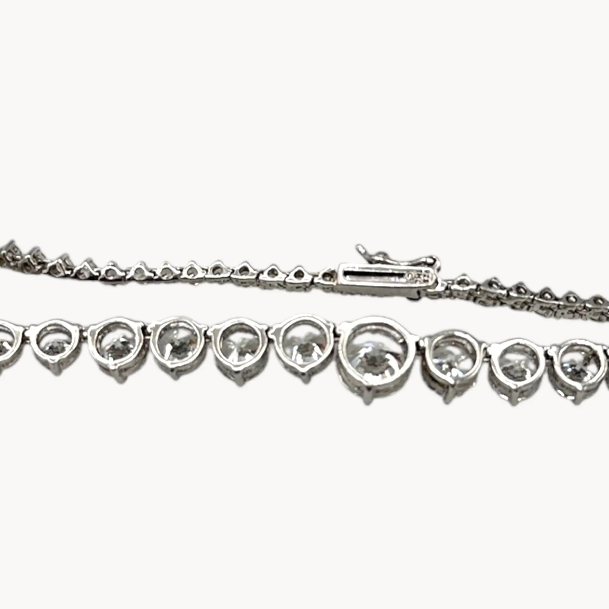 Back view of Sterling silver rhodium-plated graduated tennis necklace with round-cut stones on white background.
