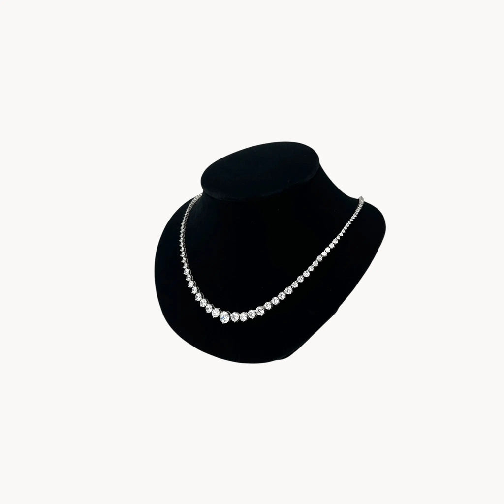 Side view of Sterling silver rhodium-plated graduated tennis necklace with round-cut stones on black bust.