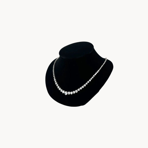 Side view of Sterling silver rhodium-plated graduated tennis necklace with round-cut stones on black bust.