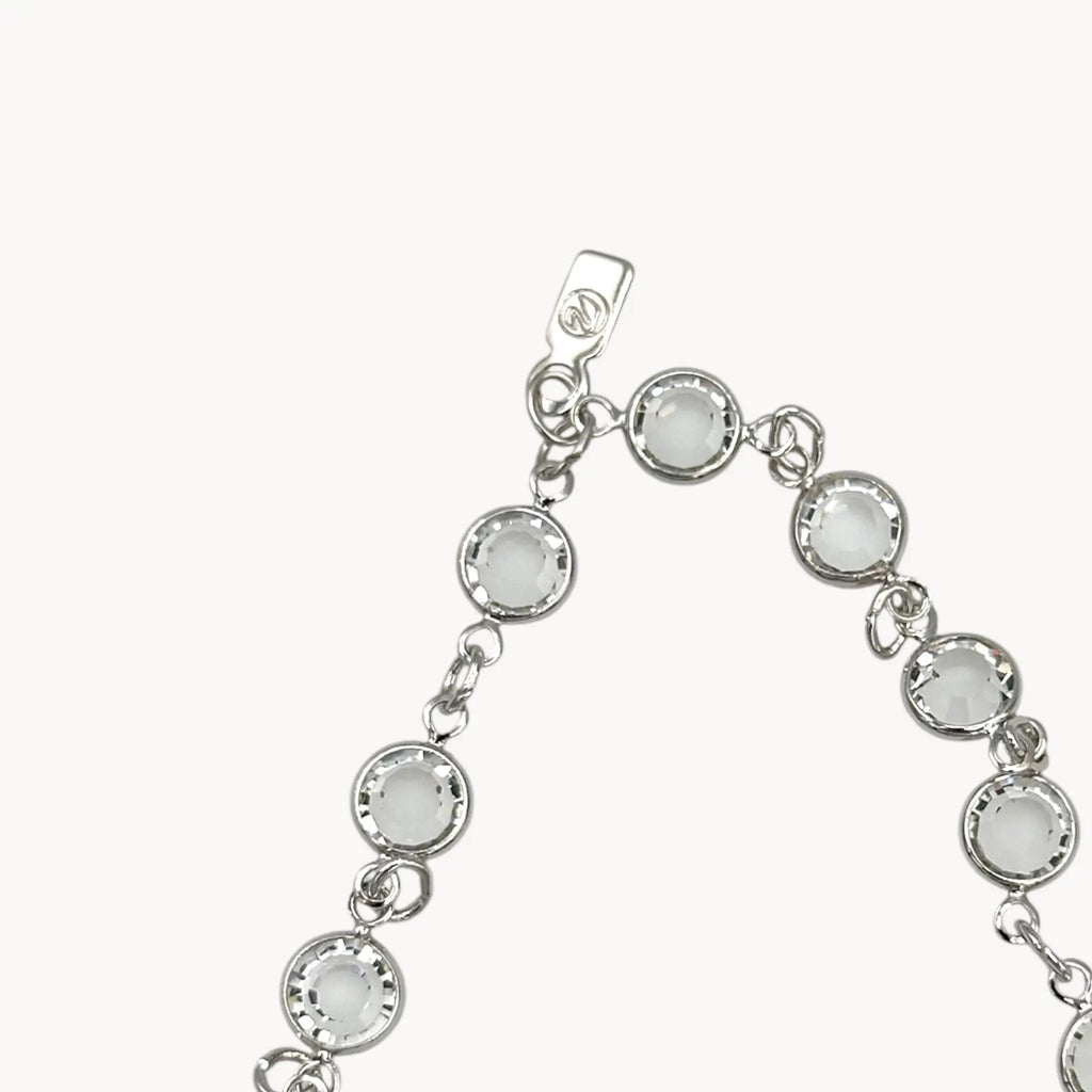 Close up of Swan hang tag of Swarovski faceted clear crystal bezel set long necklace.