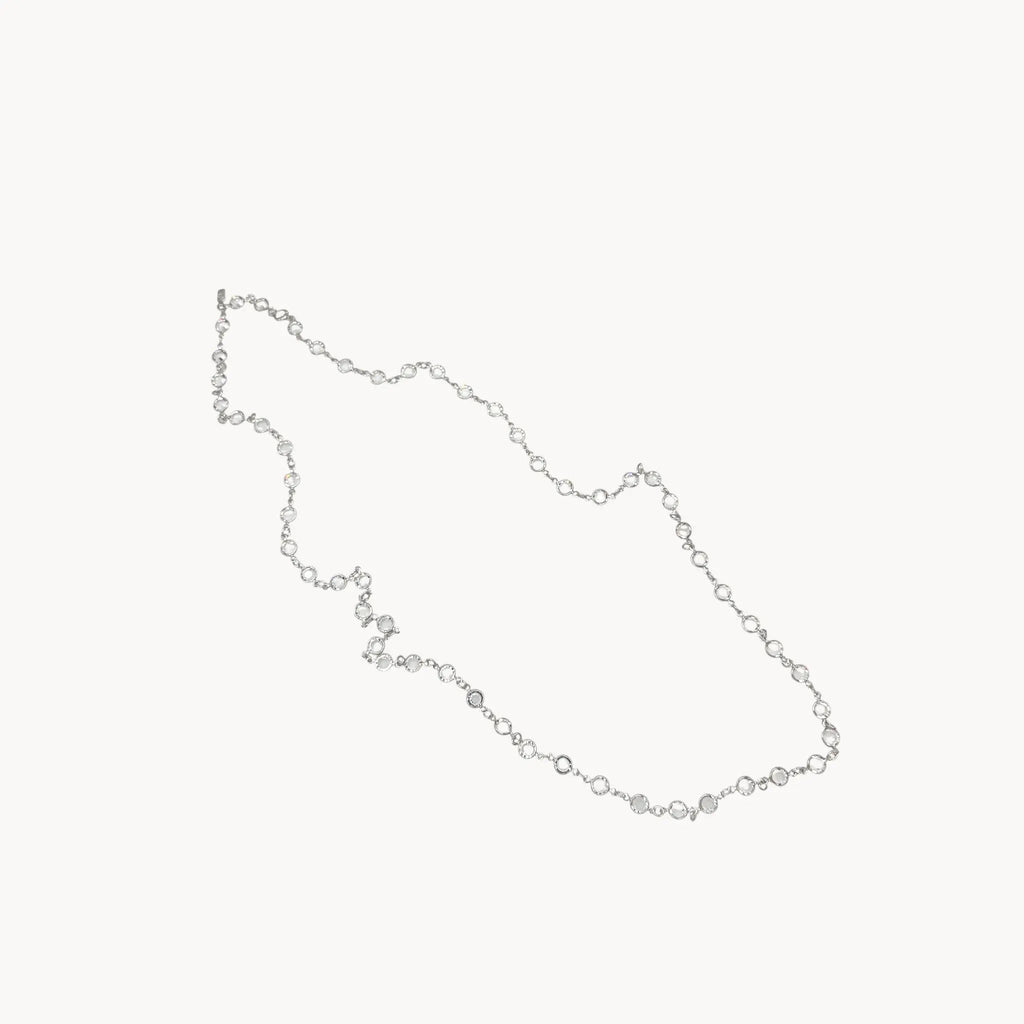 Against white background Swarovski faceted clear crystal bezel set long necklace.