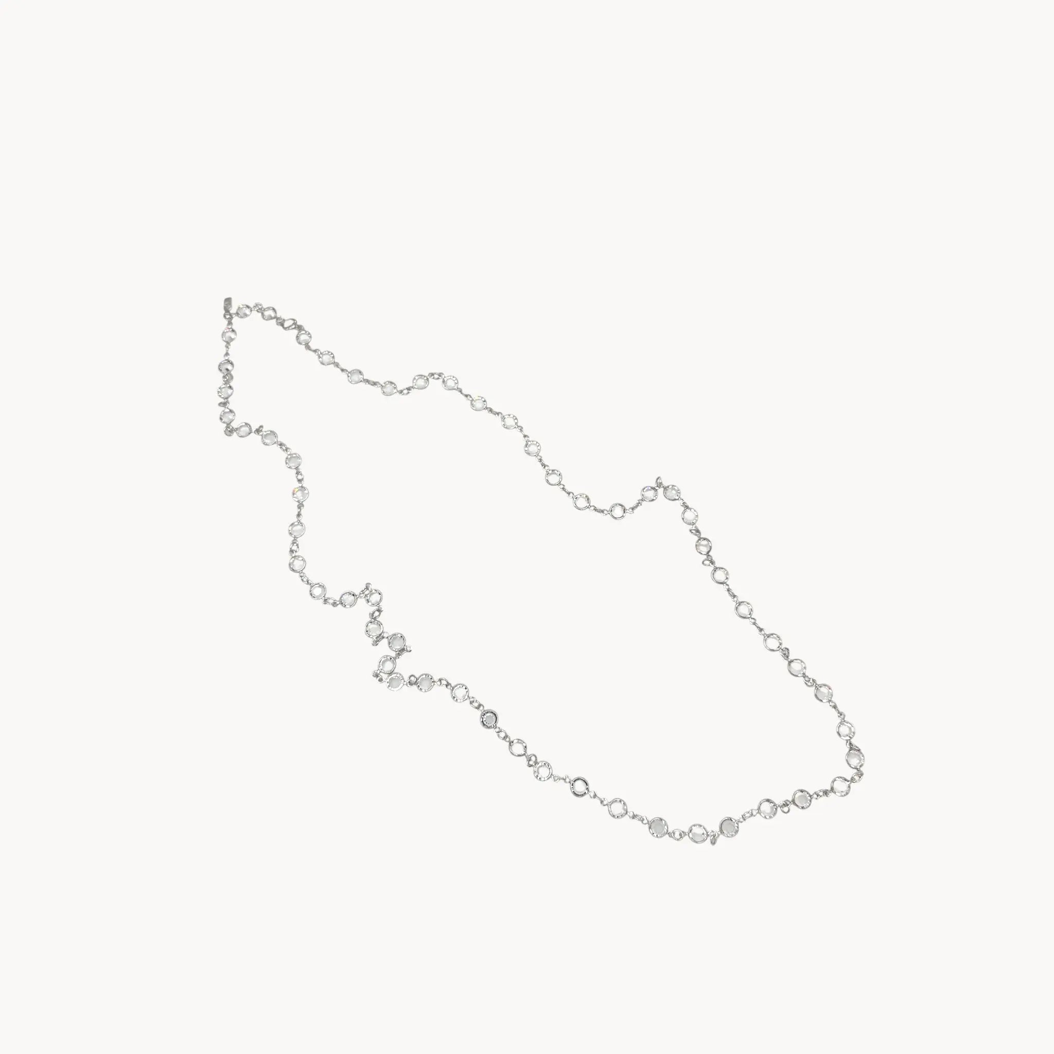 Against white background Swarovski faceted clear crystal bezel set long necklace.