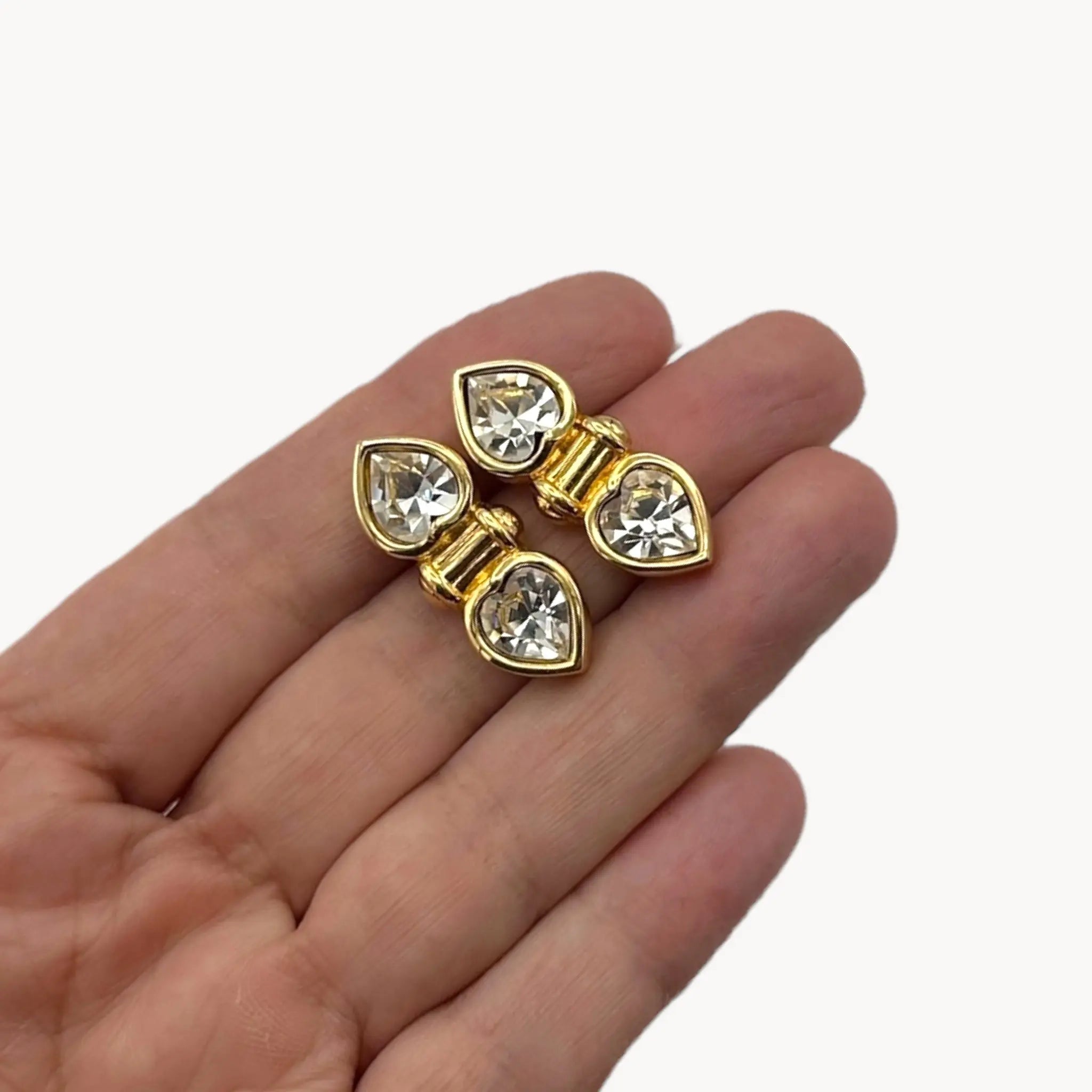 Scale size picture of Vintage Swarovski SAL clear double heart rhinestone pierced earrings.