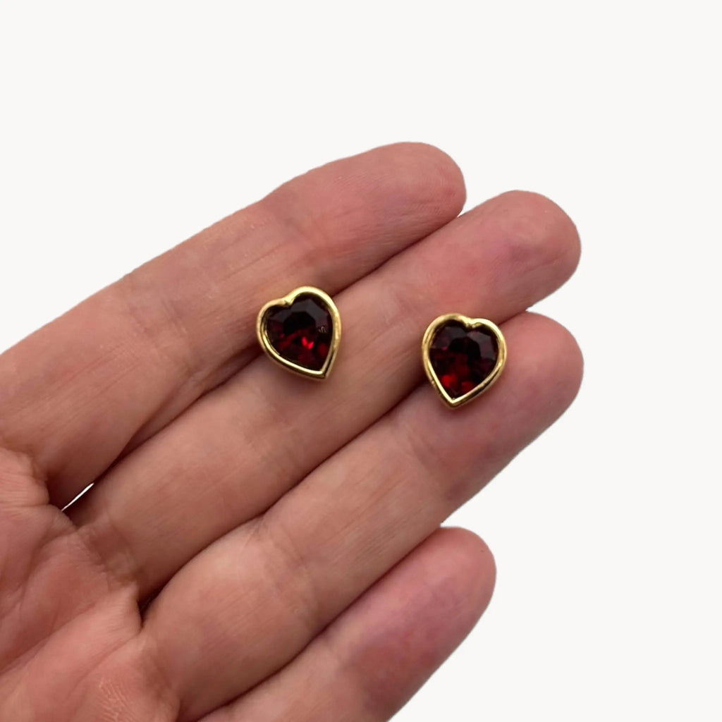 Scale size view of Swarovski SAL vintage red crystal heart pierced earrings with gold-tone setting.
