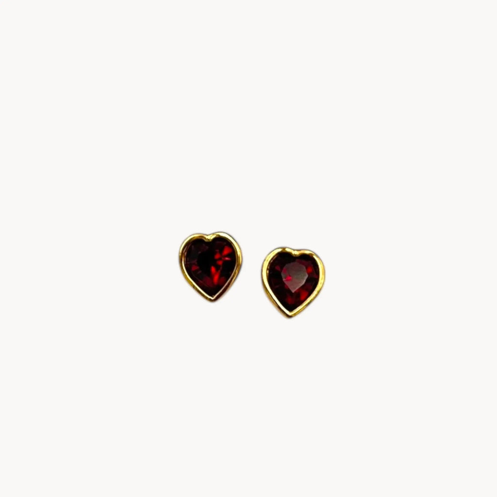 Close up view of Swarovski SAL vintage red crystal heart pierced earrings with gold-tone setting.