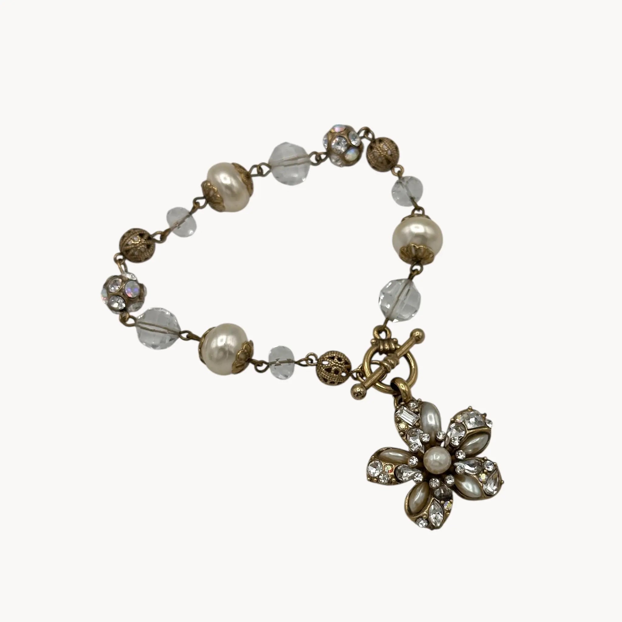 Close up on white background of Sweet Romance floral charm bracelet with pearls and rhinestones