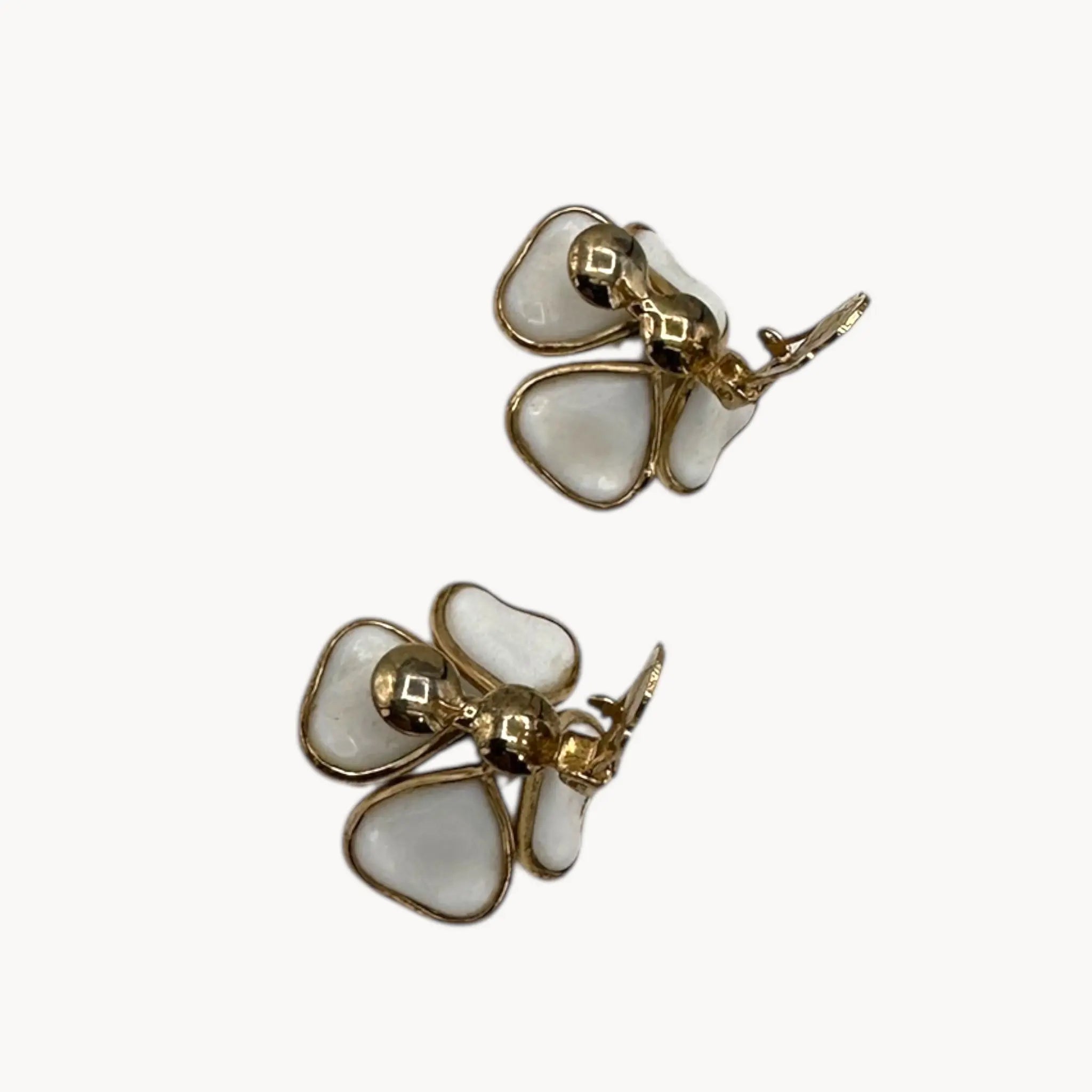Open clip view of Vintage Trifari gold-tone dogwood flower clip-on earrings with white milk glass petals on white background.