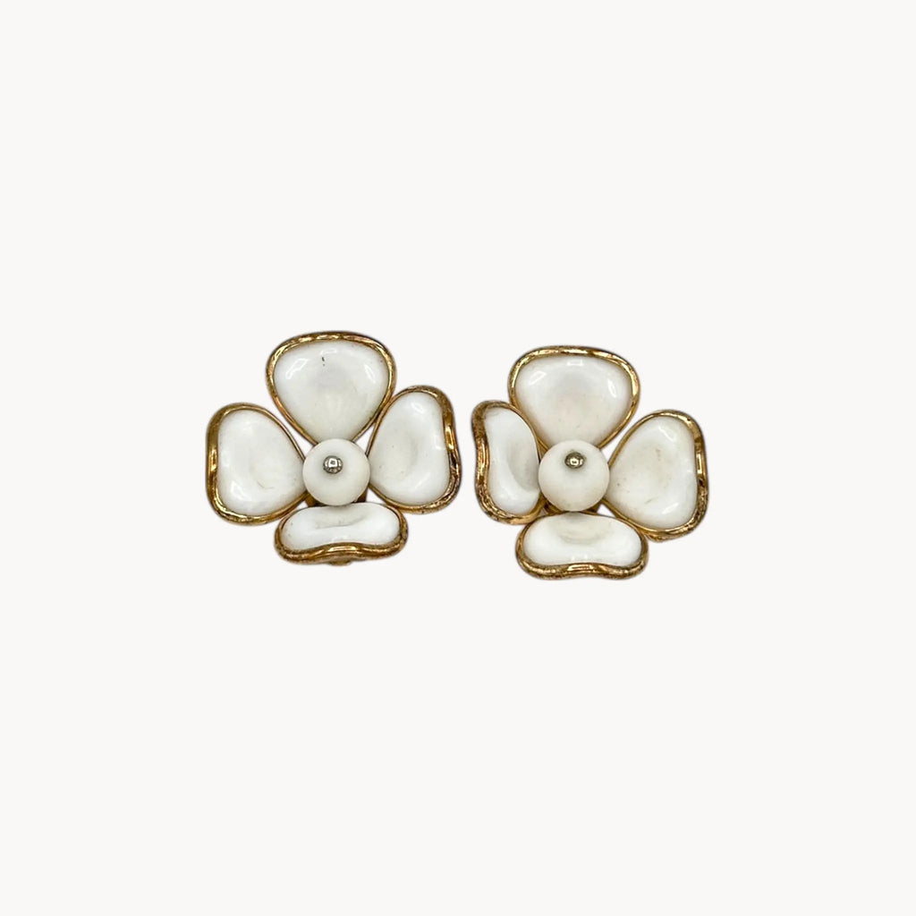 Close up view of Vintage Trifari gold-tone dogwood flower clip-on earrings with white milk glass petals on white background.