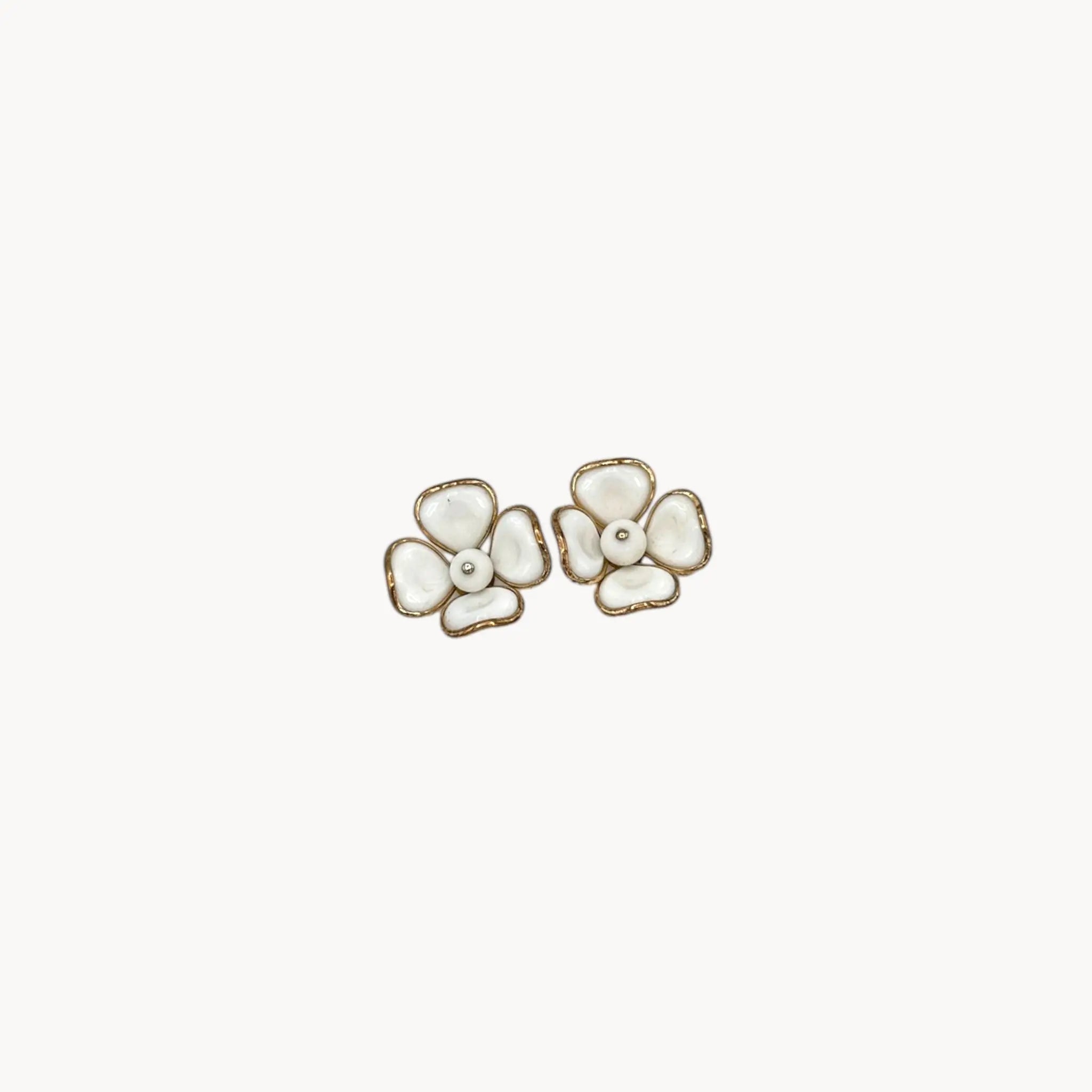 Vintage Trifari gold-tone dogwood flower clip-on earrings with white milk glass petals on white background.