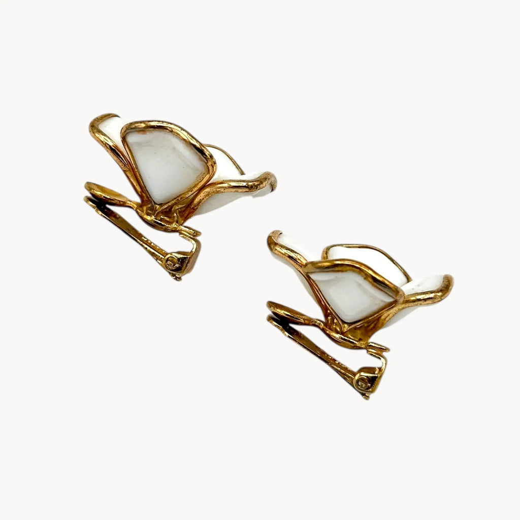 Clip view of Vintage Trifari gold-tone dogwood flower clip-on earrings with white milk glass petals on white background.