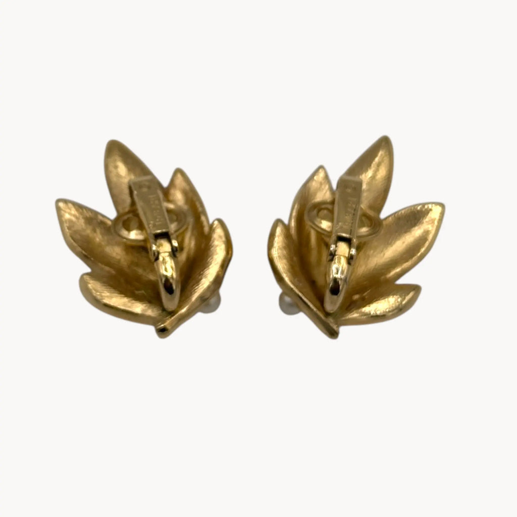 Back view of Vintage Trifari gold leaf clip-on earrings with faux pearls, 1960s jewelry on white background.