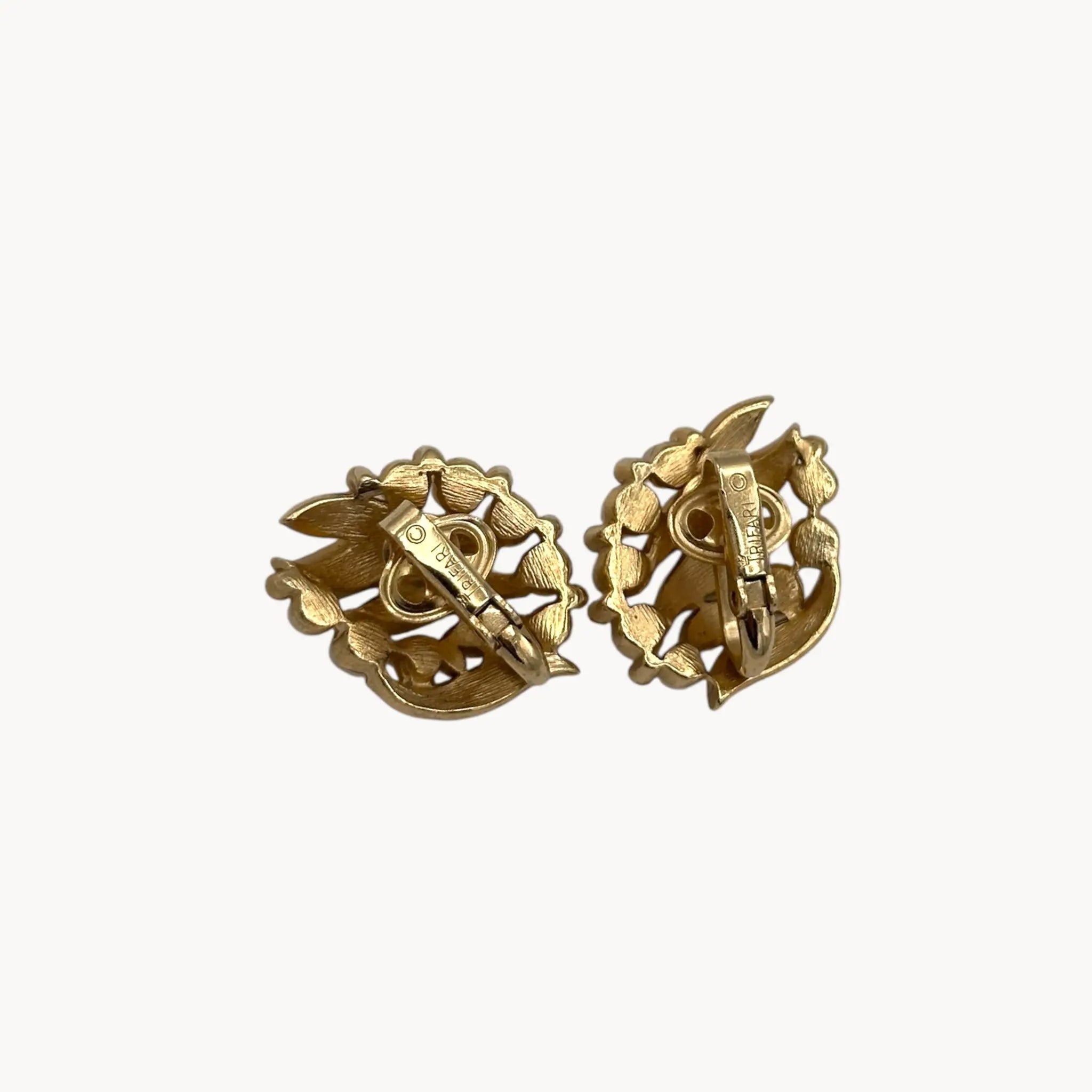 Back view of Vintage Trifari gold floral clip-on earrings with faux pearls and rhinestones, 1960s jewelry on white background.