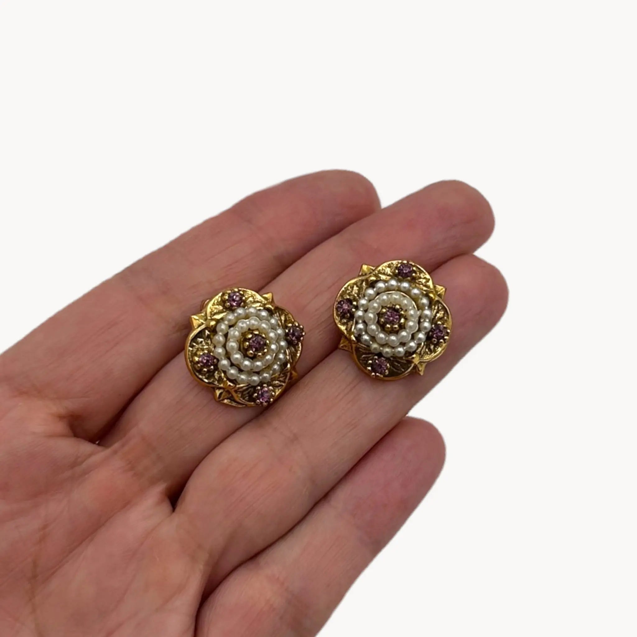 Scale size view of Victorian revival gold clip-on earrings with faux pearls and purple rhinestones.